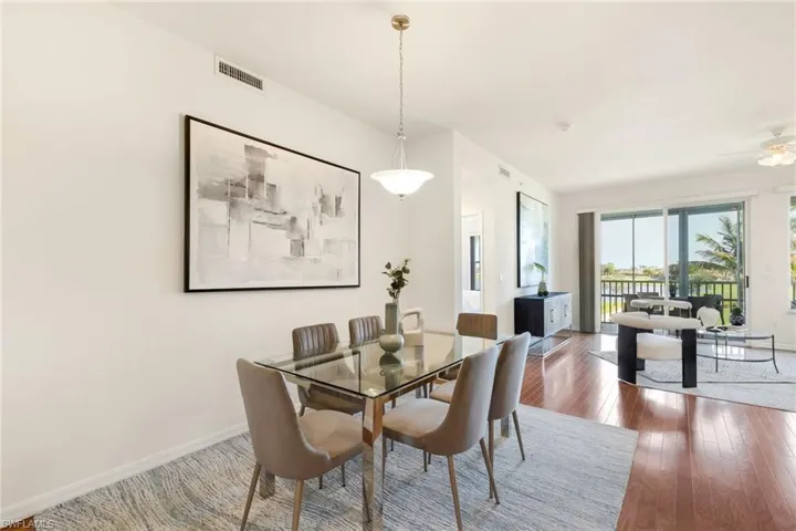 Dining room with wood flooring and views into the living room and outside