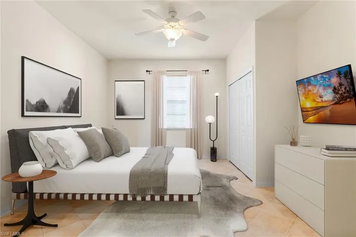 Bedroom featuring light tile patterned floors, ceiling fan, and a closet. This photo is virtually staged.