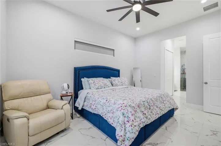 Bedroom with a closet, a ceiling fan, light marble finish flooring, and recessed lighting