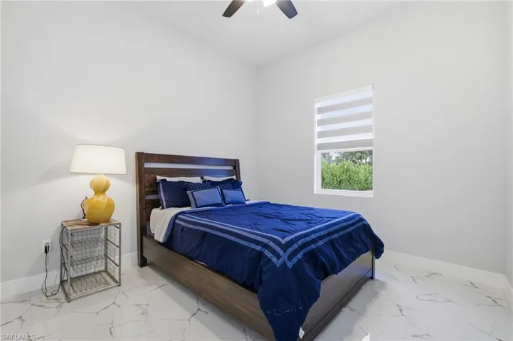 Bedroom featuring marble finish floors and ceiling fan