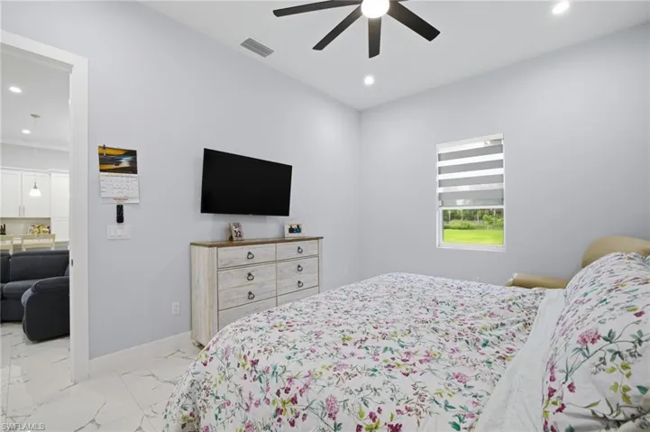 Bedroom featuring light marble finish flooring, ceiling fan, and recessed lighting