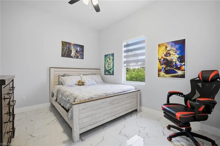 Bedroom featuring light marble finish flooring and ceiling fan