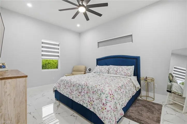 Bedroom featuring light marble finish floors, a ceiling fan, and recessed lighting