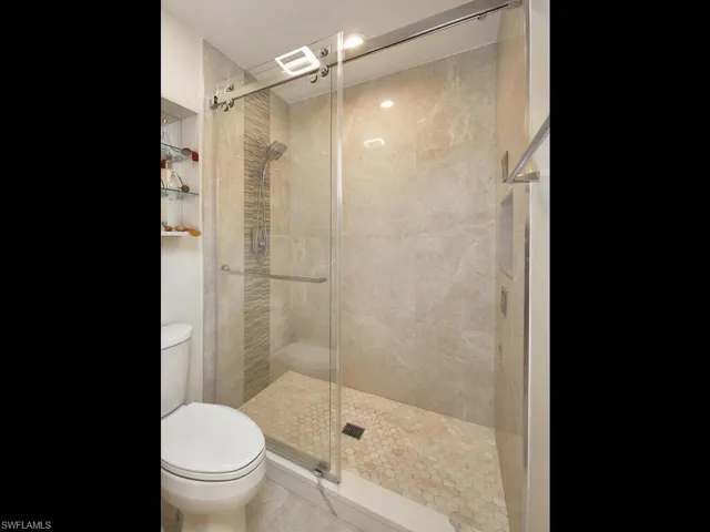 Glass-enclosed shower with sleek tile and spa-like ambiance.