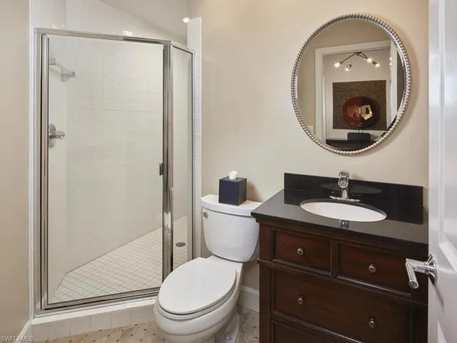 Elegant bathroom with a glass-enclosed shower and rich wood vanity.