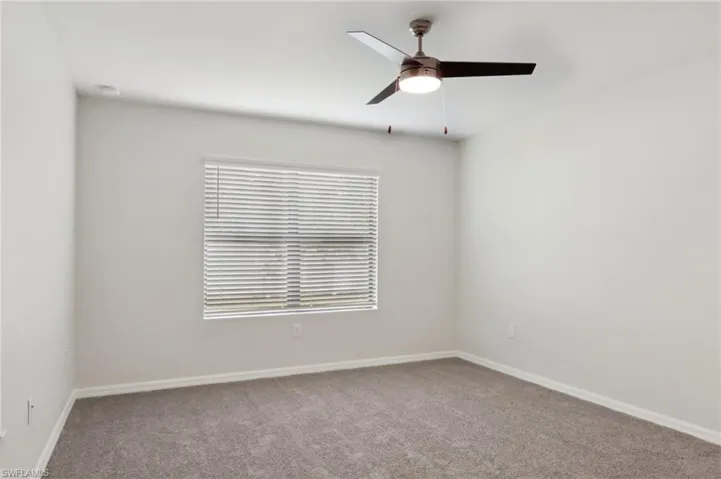 Unfurnished room with carpet flooring, a ceiling fan, and baseboards