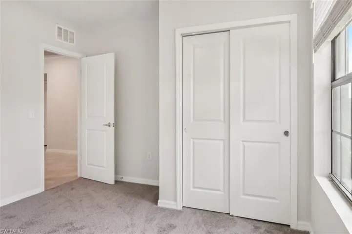 Unfurnished bedroom with a closet, baseboards, visible vents, and carpet