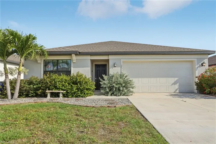 View of front of house featuring concrete driveway, stucco siding, an attached garage, a front lawn, and a shingled roof