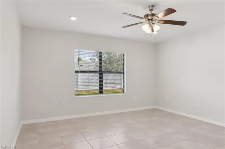 Spare room featuring a ceiling fan and baseboards