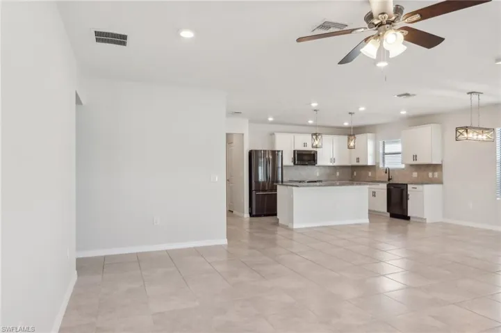 Kitchen with tasteful backsplash, stainless steel appliances, a kitchen island, visible vents, and a ceiling fan