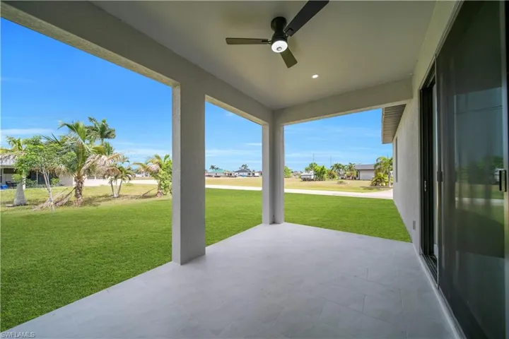 Covered patio with a ceiling fan and recessed lighting, featuring tiled flooring and a sliding glass door
