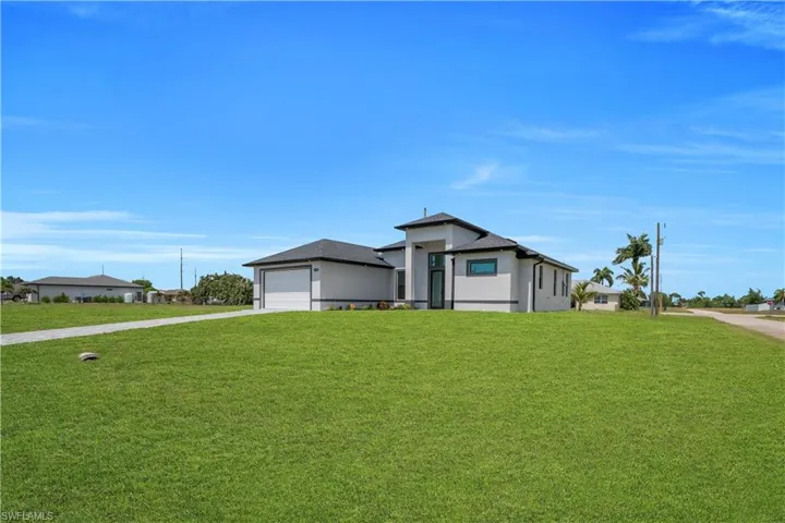 Contemporary stucco exterior with a multi-gabled roofline, integrated garage, and a prominent entryway