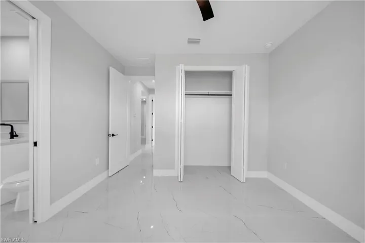 Interior room featuring light gray walls, white baseboards, and a contemporary ceiling fan