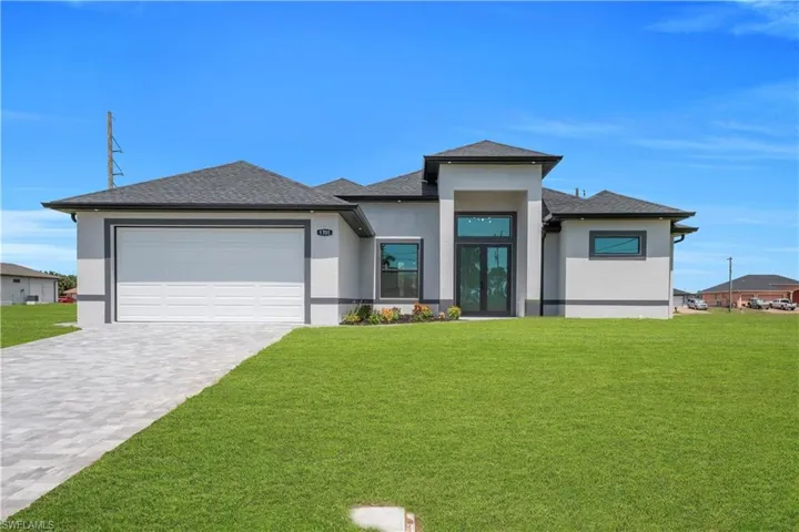 Contemporary stucco exterior with dark trim accents and a paver driveway