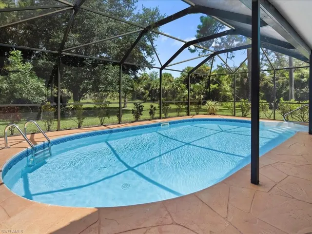 Outdoor pool with glass enclosure, a sunroom, and a patio area