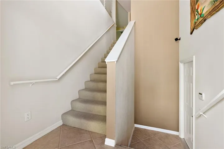 Stairway featuring tile patterned flooring and baseboards