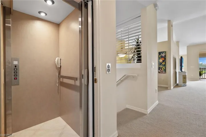 Elevator featuring baseboards and phonr