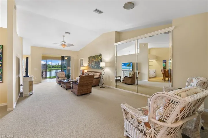 Bedroom featuring access to exterior, visible vents, lofted ceiling, and carpet floors