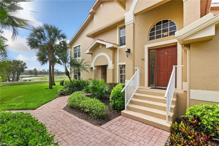 Doorway to property with a yard and stucco siding