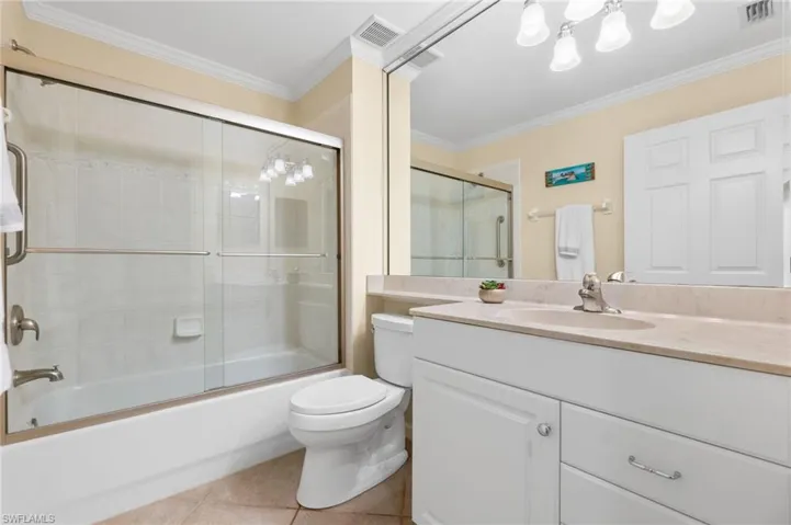 Bathroom featuring ornamental molding, visible vents, toilet, and tile patterned flooring