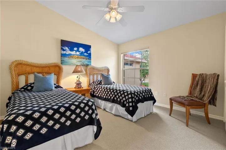 Carpeted bedroom with baseboards, a ceiling fan, and vaulted ceiling