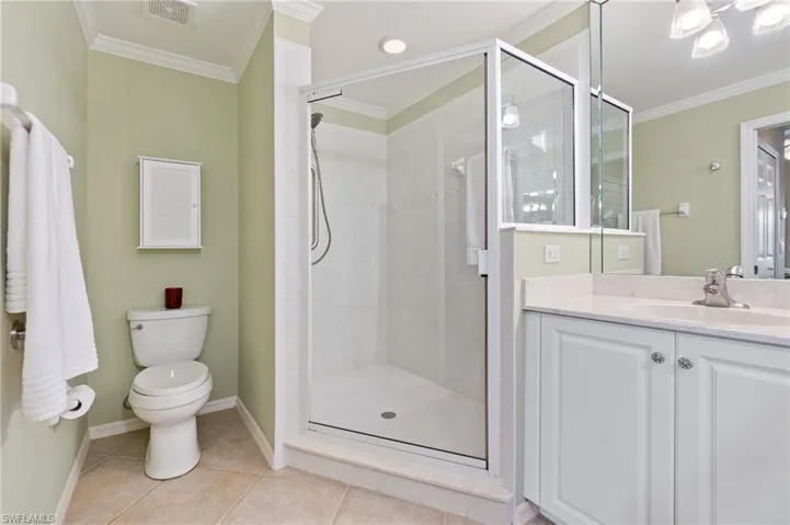 Full bathroom with tile patterned floors, visible vents, ornamental molding, and a stall shower