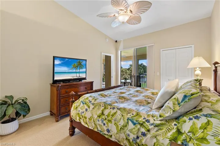 Bedroom featuring access to outside, a ceiling fan, vaulted ceiling, light carpet, and baseboards