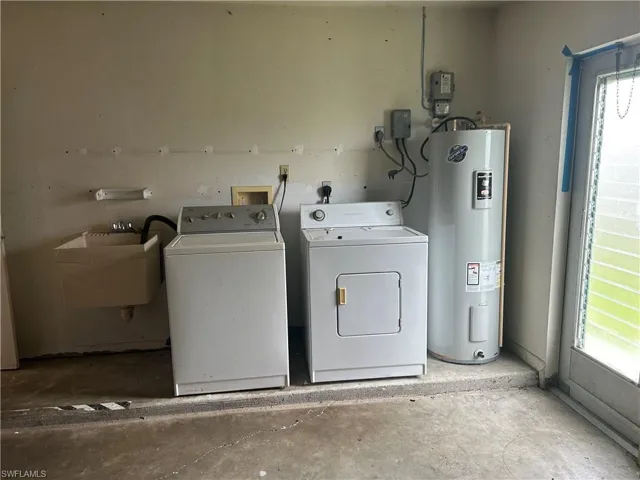 Washroom featuring water heater and independent washer and dryer