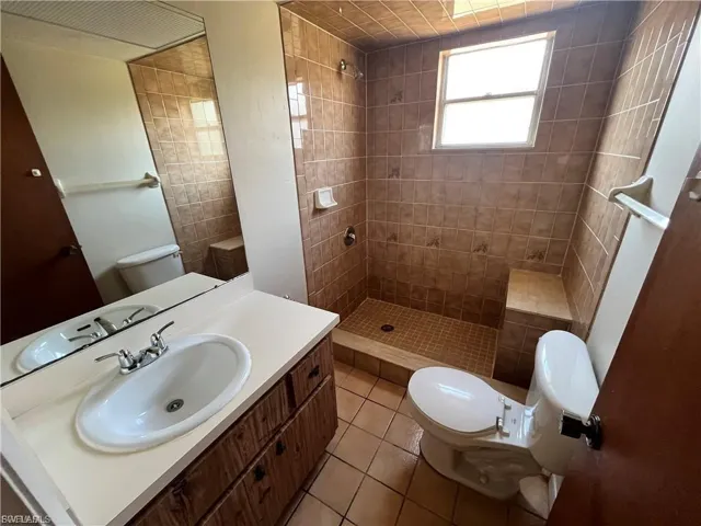 Full bath featuring vanity, a shower stall, and light tile patterned floors