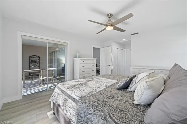Bedroom with light wood-type flooring, ceiling fan, and a closet