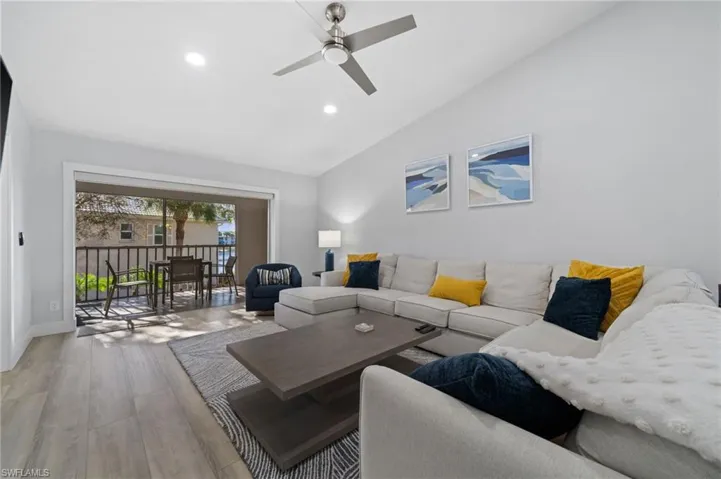 Living area with light wood-type flooring, a ceiling fan, lofted ceiling, and recessed lighting