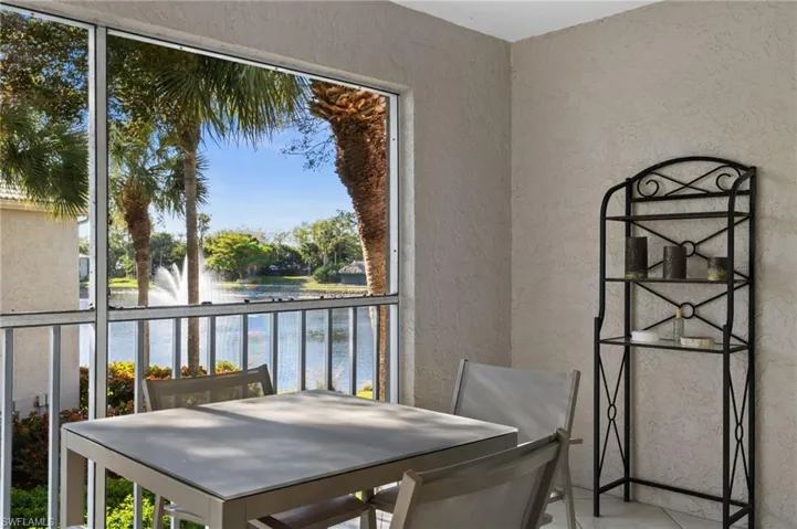Balcony featuring a sunroom, outdoor dining area, and a water view