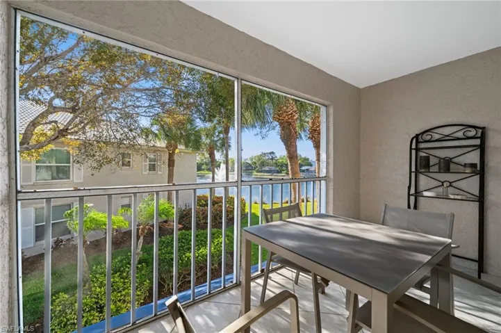 Balcony featuring a sunroom, a water view, and outdoor dining area