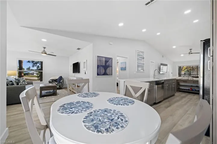 Dining space featuring ceiling fan, light wood-style flooring, vaulted ceiling, and recessed lighting