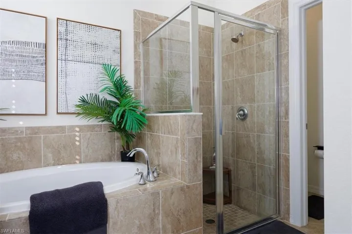 Full bath featuring a bath and a shower stall