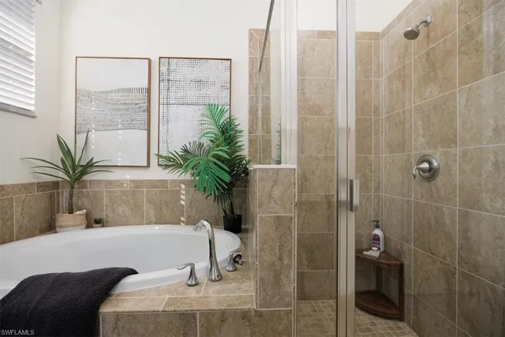 Bathroom featuring a garden tub and a shower stall