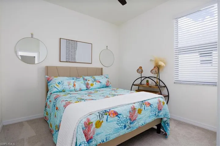 Bedroom featuring light colored carpet and a ceiling fan