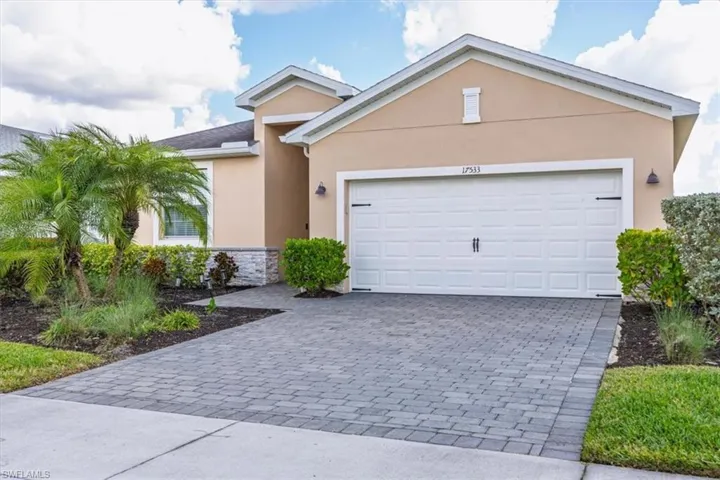 Ranch-style home with stucco siding, decorative driveway, and a garage
