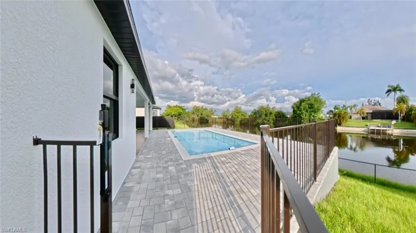 View of swimming pool featuring a fenced backyard, a patio, and a water view