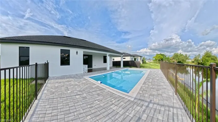 View of swimming pool with a patio and a fenced backyard