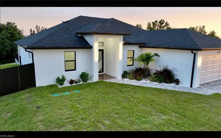 View of front of house featuring a garage, roof with shingles, and stucco siding