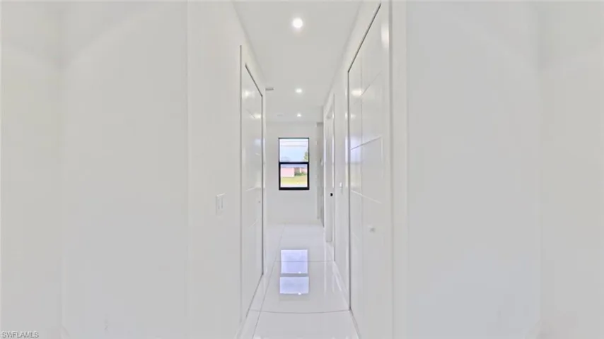 Corridor with light tile patterned floors and recessed lighting