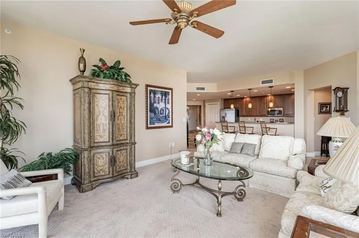 Carpeted living room featuring ceiling fan