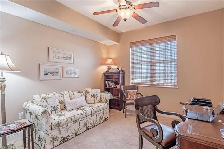 Carpeted office featuring ceiling fan