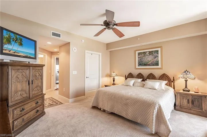 Carpeted bedroom featuring ceiling fan