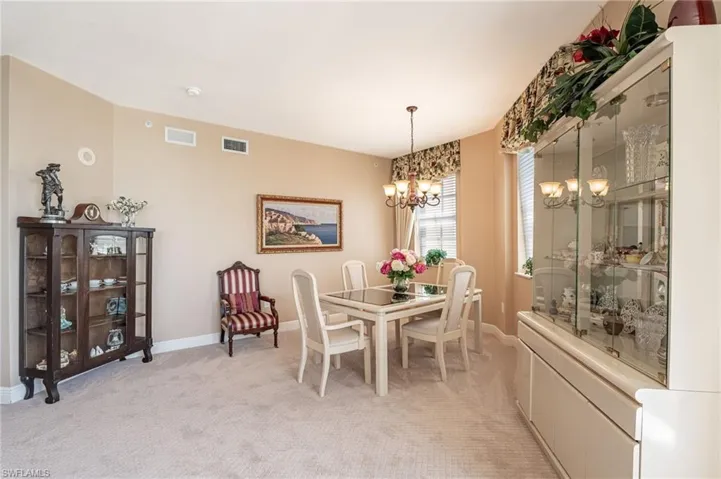 Carpeted dining space featuring a chandelier