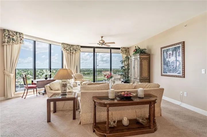 Living room featuring light carpet, ceiling fan, and a wealth of natural light