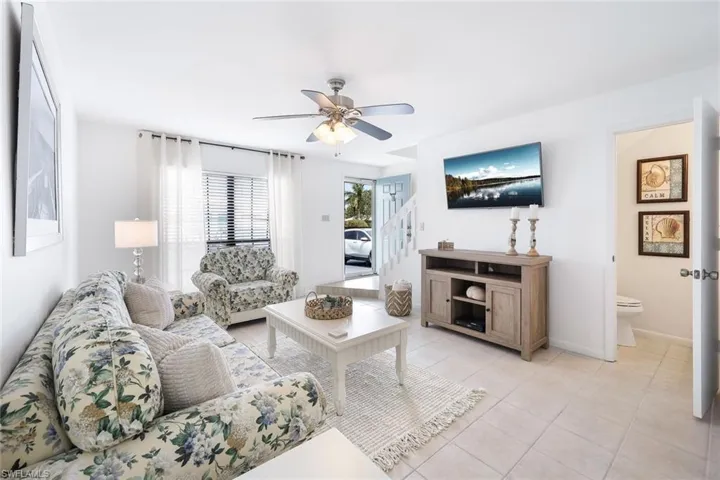 Living room featuring light tile patterned floors and ceiling fan