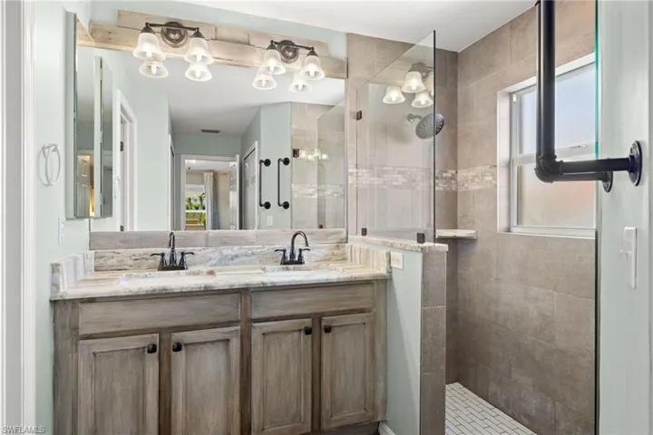 Bathroom with dual vanity, tiled shower