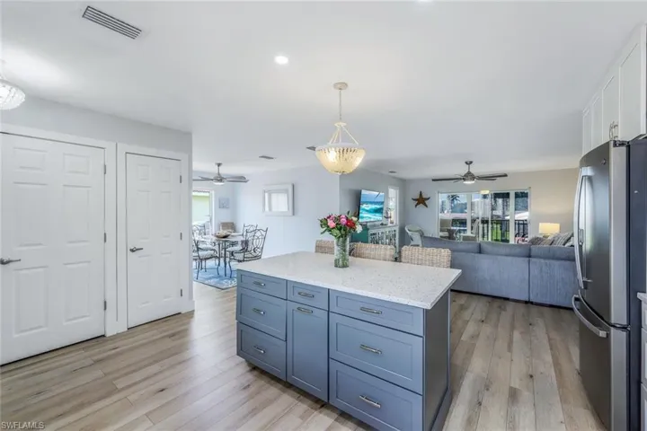 Kitchen featuring white cabinetry, stainless steel refrigerator, light wood-type flooring, and ceiling fan